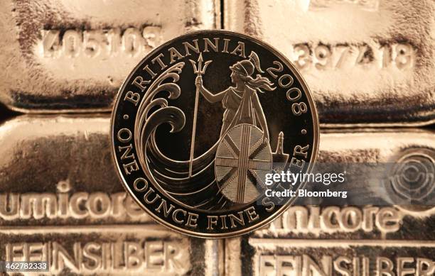 British one ounce silver coin sits on one kilogram silver bars in this arranged photograph at Gold Investments Ltd. Bullion dealers in London, U.K.,...