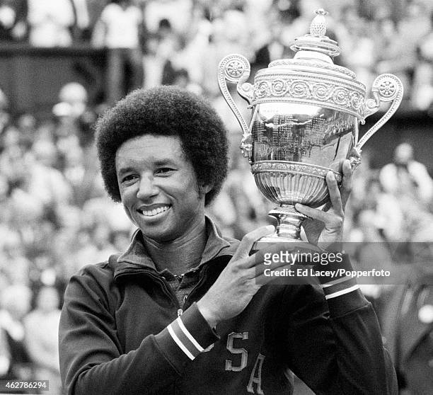 Arthur Ashe of the United States holding the Wimbledon trophy after winning the Men's Singles final, defeating Jimmy Connors of the United States in...
