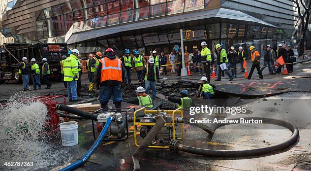 Workers use generators to pump water out of a hole in the street, caused by a water main break on 5th Ave and 13th St. On January 15, 2014 in New...