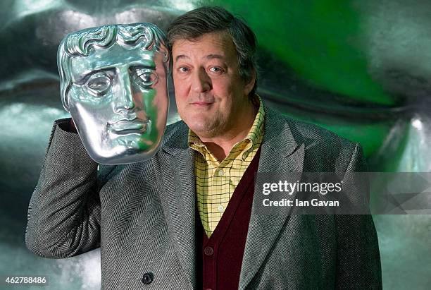 Stephen Fry poses on stage with a BAFTA mask ahead of the British Academy Film Awards at The Royal Opera House on February 5, 2015 in London,...