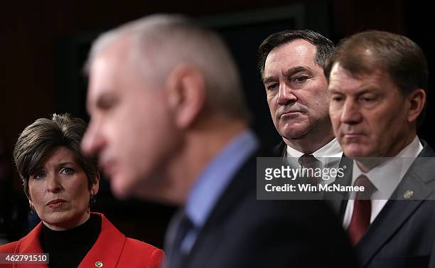 Sen. Joni Ernst listens to questions during a press conference as Sen. Jack Reed speaks at the U.S. Capitol February 5, 2015 in Washington, DC. A...