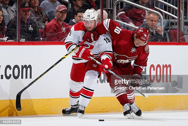 Jiri Tlusty of the Carolina Hurricanes and Martin Erat of the Arizona Coyotes battle for the puck during the first period of the NHL game at Gila...
