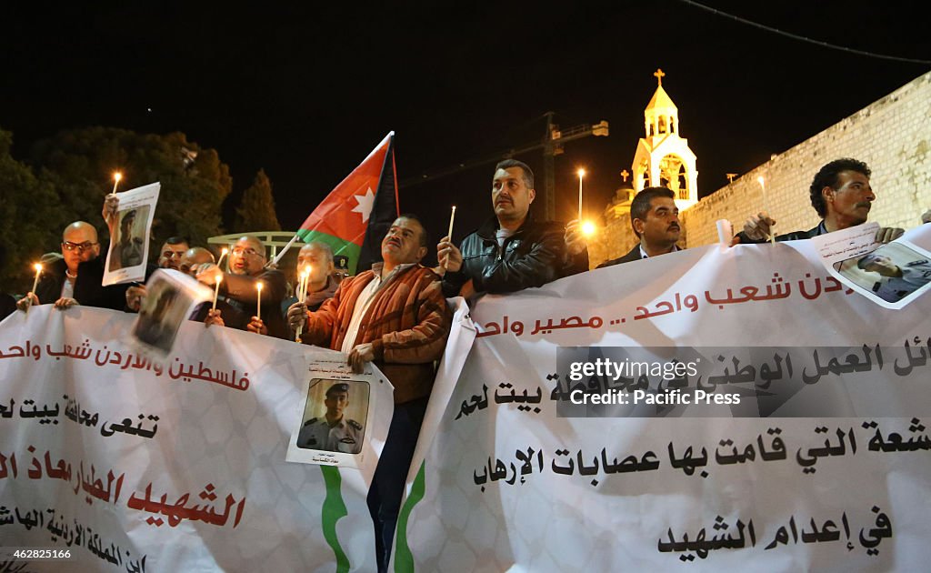 Palestinians hold candles and portraits of slain Jordanian...
