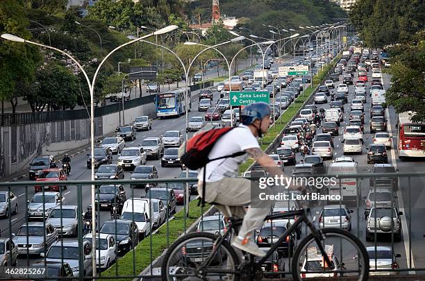 Homem anda de bicicleta em tarde de trânsito congestionado na avenida 23 de Maio em São Paulo. | Man rides a bicycle in afternoon of high traffic on...