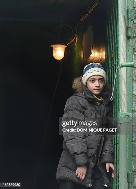 Artium,10-years-old, stands at the entrance of a bomb shelter in Donetsk's Kiyevski district, in the eastern Ukraine on February 5, 2015. Donetsk's...