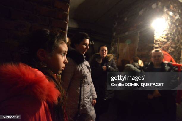 Ania, 11-years-old, and residents wait for the end of the shelling in Donetsk's Petrovski district, in the eastern Ukraine on February 4, 2015....