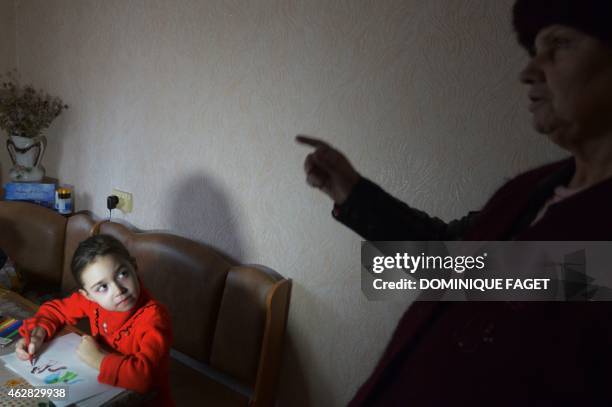 Sofia, 6-years-old , draws a picture while her grandmother sings a patriotic song in Donetsk's Kiyevski district, in the eastern Ukraine on February...