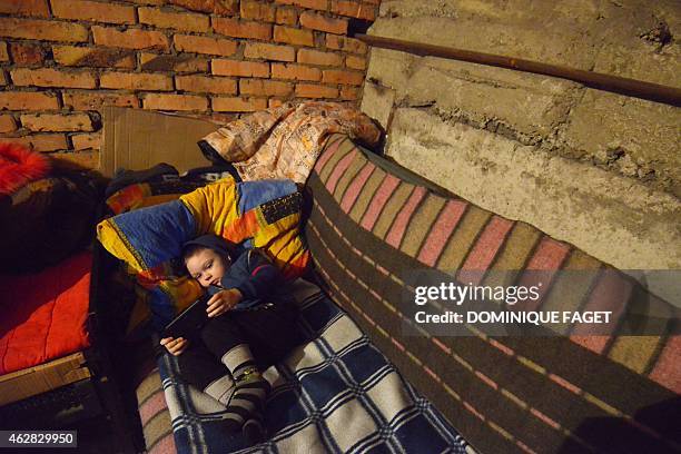 Michal, 4-years-old, lies on a make shift bed as he and others wait for the end of the shelling in Donetsk's Petrovski district, in the eastern...