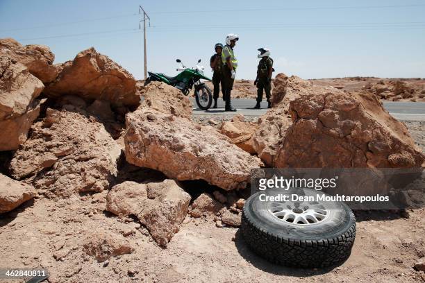 Nani Roma of Spain and Michel Perin of France for MINI and the Monster Energy X-Raid Team leave a flat tyre raod side after they stop to change it in...