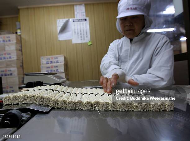 Japanese somen maker makes 50g bundles of Ibonoito somen noodles on the production line on February 6, 2015 in Tatsuno, Japan. Somen is a type of...