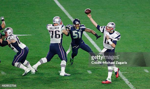 Tom Brady of the New England Patriots passes, as Sebastian Vollmer block Bruce Irvin of the Seattle Seahawks, during the game at the University of...