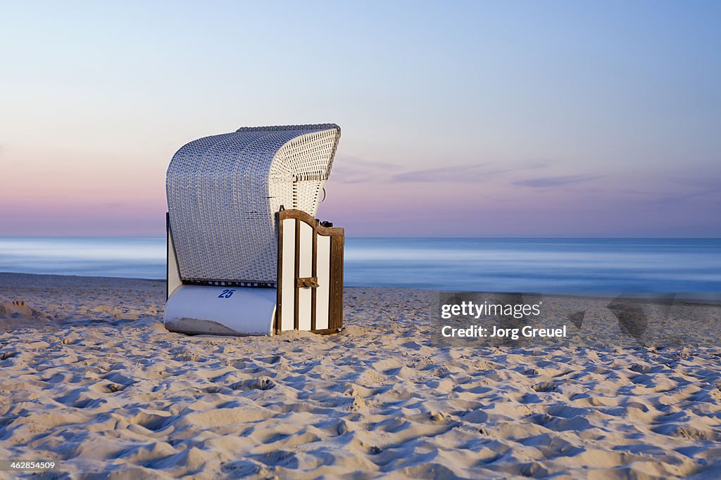 Wicker beach chair at dusk
