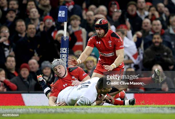 Anthony Watson of England scores his team's opening try despite the tackle from Jonathan Davies of Wales during the RBS Six Nations match between...