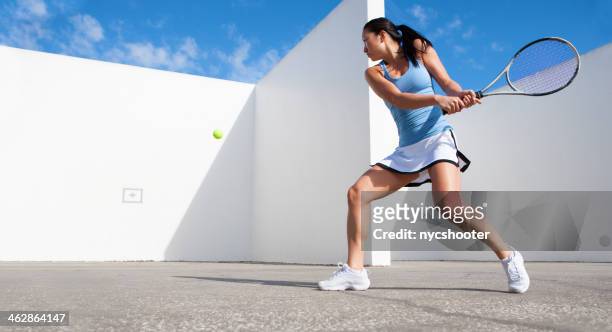 jeune femme frapper tennis ball contre le mur - tennis photos et images de collection