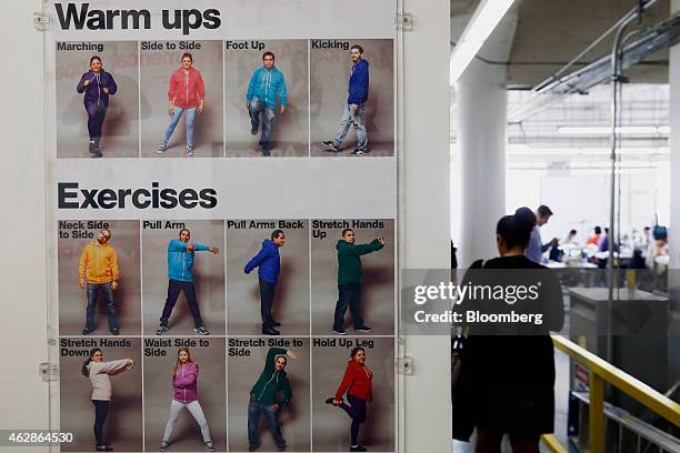 Employees are pictured in a poster of exercises to complete during work hours at the American Apparel Inc. Factory in downtown Los Angeles,...