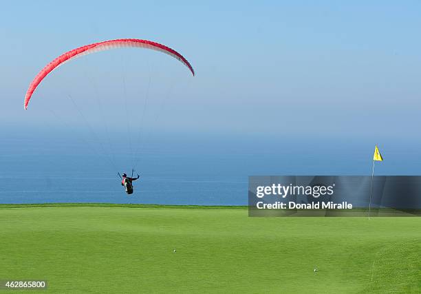 Paraglider flies over the fourth green on the south course during round two of the Farmers Insurance Open at Torrey Pines Golf Course on February 6,...
