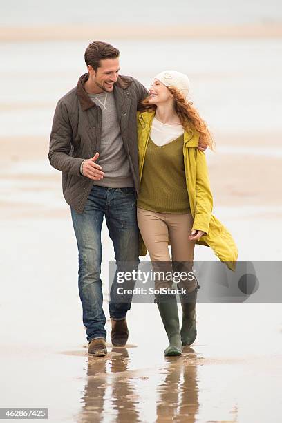 young couple walking on the beach - short guy tall woman stock pictures, royalty-free photos & images