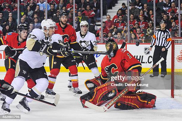 Jonas Hiller of the Calgary Flames stops the shot of Sidney Crosby of the Pittsburgh Penguins during an NHL game at Scotiabank Saddledome on February...