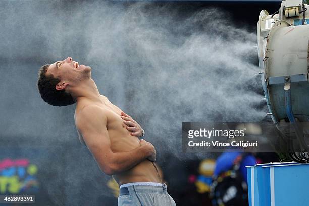 Jerzy Janowicz of Poland in front of fan coolers at Grand Slam Oval during day 4 of the 2014 Australian Open at Melbourne Park on January 16, 2014 in...