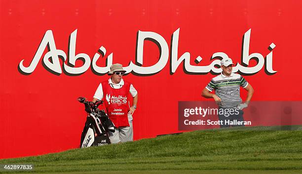 Jamie Donaldson of Wales waits with his caddie Mick Donaghy on the 18th hole during the first round of the Abu Dhabi HSBC Golf Championship at the...