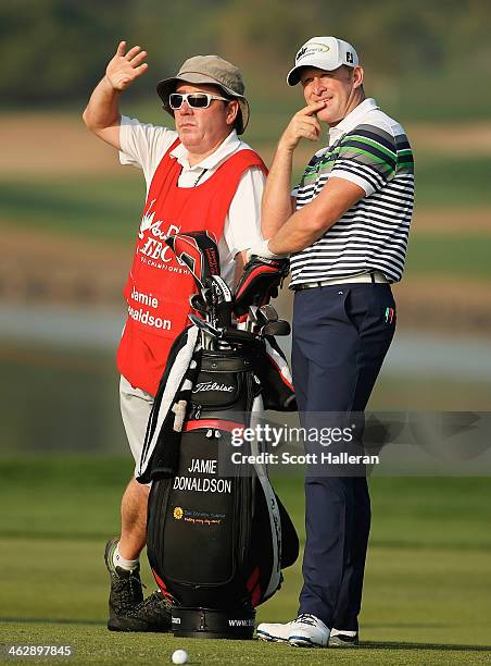 Jamie Donaldson of Wales waits with his caddie Mick Donaghy on the 14th hole during the first round of the Abu Dhabi HSBC Golf Championship at the...
