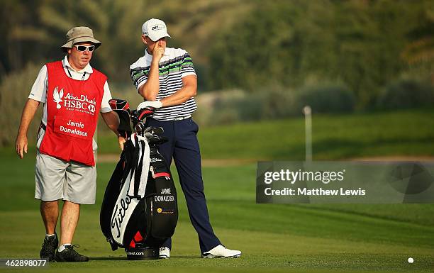 Jamie Donaldson of Wales looks on with his caddie Mick Donaghy during day one of the Abu Dhabi HSBC Golf Championship at Abu Dhabi Golf Club on...