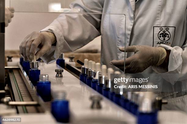 An employee of the Apivita ecological cosmetic company checks products at the company workshops in Markopoulo, south of Athens, on February 2, 2015....