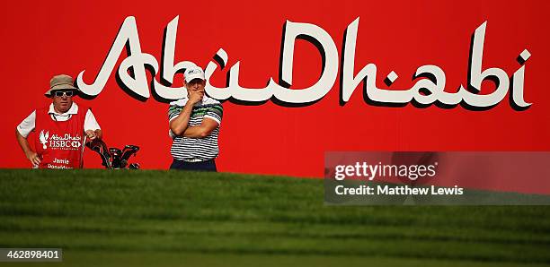 Jamie Donaldson of Wales looks on with his caddie Mick Donaghy during day one of the Abu Dhabi HSBC Golf Championship at Abu Dhabi Golf Club on...