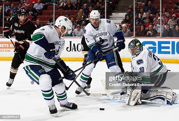 Kevin Bieksa and Joacim Eriksson look on as Dan Hamhuis of the Vancouver Canucks handles the puck against the Anaheim Ducks on January 15, 2014 at...