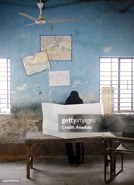 An Indian muslim women voter casts her ballot at a polling station in New Delhi on February 7, 2015.