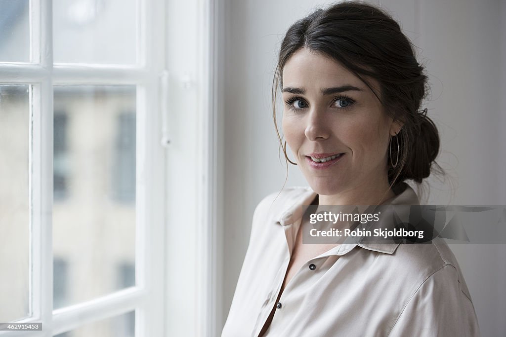 Woman standing by window smiling