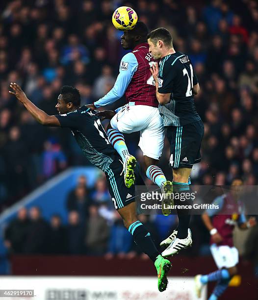 Christian Benteke of Aston Villa jumps for the ball with Mikel John Obi and Gary Cahill of Chelsea during the Barclays Premier League match between...