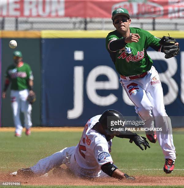 Mexico National baseball team shortstop forces out Dominican National baseball player Alexi Casilla at second base and makes the throw to first base...
