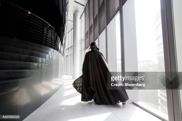 An actor dressed as Darth Vader, a Star Wars character, poses for a photograph during the opening ceremony for Lucasfilm Ltd.'s Sandcrawler building,...