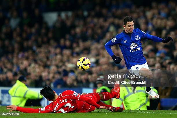 Emre Can of Liverpool slides in on Bryan Oviedo of Everton during the Barclays Premier League match between Everton and Liverpool at Goodison Park on...