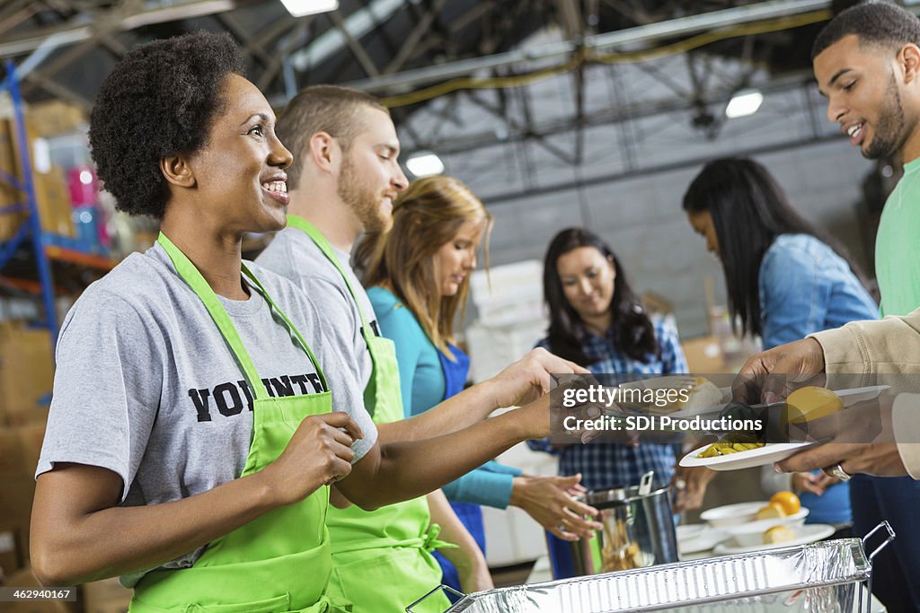 Volunteers serving healthy hot meal at soup kitchen