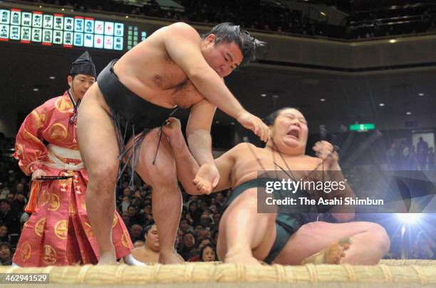 Satoyama throws Kagamio on day four of the Grand Sumo New Year Tournamnet at Ryogoku Kokugikan on January 15, 2014 in Tokyo, Japan.