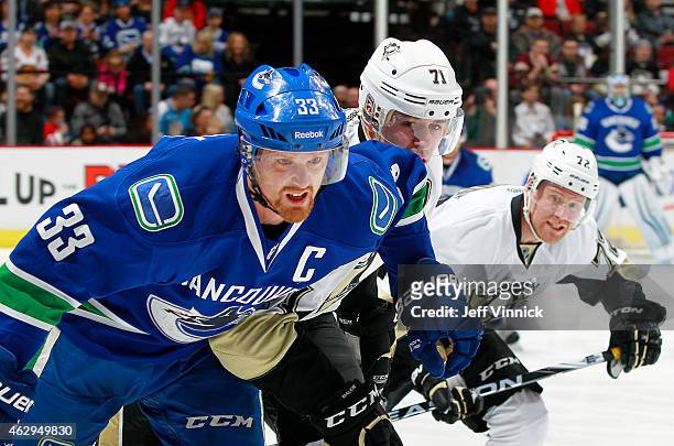 Daniel Sedin of the Vancouver Canucks, Evgeni Malkin and Patric Hornqvist of the Pittsburgh Penguins follow the play during their NHL game at Rogers...