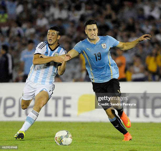 Cristian Espinoza of Argentina and Erick Cavaco of Uruguay fight for the ball during a match between Argentina and Uruguay as part of South American...