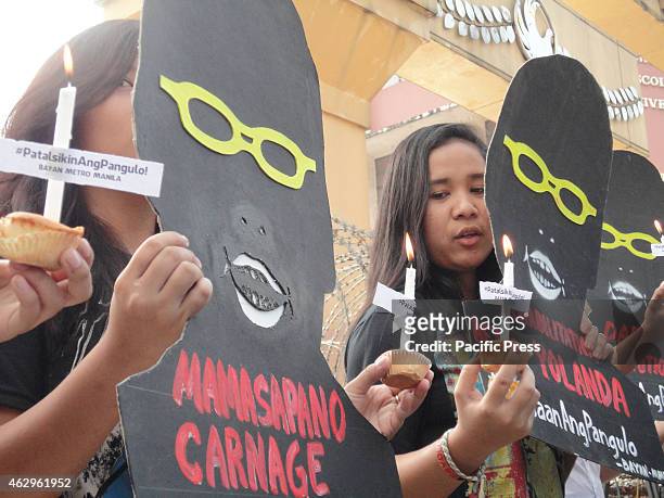 Filipino protesters hold cupcakes with candles and shadow cut-outs of President Benigno Aquino III near the Malacanang presidential palace, a day...