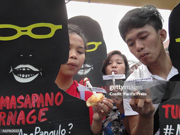 Filipino protesters holding shadow cut-outs of blow candles placed on cupcakes near Malacanang presidential palace, a day before President Aquino's...