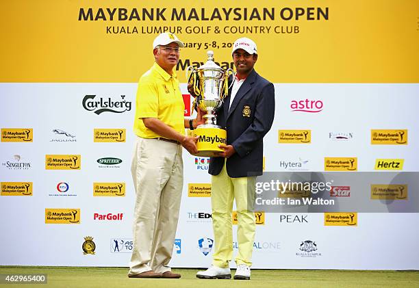 Anirban Lahiri of India is presented with the trophy by Prime Minister of Malaysia Abdul Razak after victory during the final round of the Maybank...