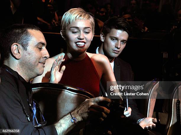Photographer Larry Busacca with singer Miley Cyrus and Patrick Schwarzenegger attend the Pre-GRAMMY Gala and Salute to Industry Icons honoring Martin...