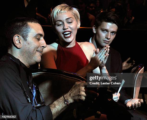 Photographer Larry Busacca with singer Miley Cyrus and Patrick Schwarzenegger attend the Pre-GRAMMY Gala and Salute to Industry Icons honoring Martin...