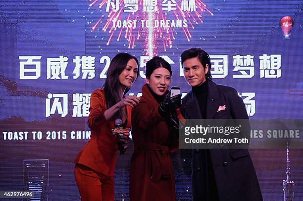 Actors Maggie Q and Chen Kun speak on stage during Maggie Q toasts the Chinese New Year at Times Square on February 7, 2015 in New York City.