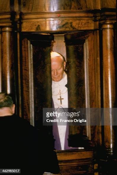 Pope John Paul II opens the shutters of the confessional where he has ...