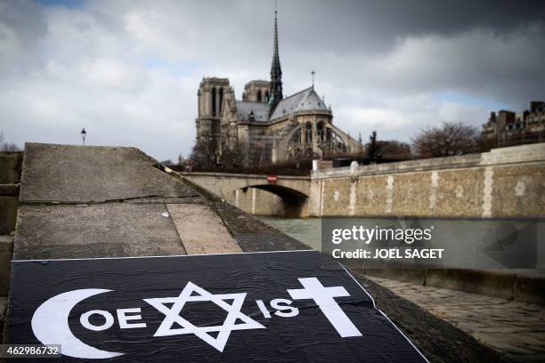 Poster by French street artist Combo is pictured after being stuck on the Quai de la Tournelle, near the Arab World Institute on February 8, 2015 in...