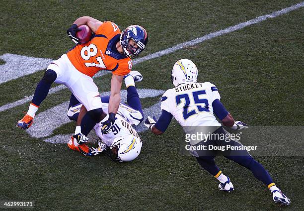 Eric Decker of the Denver Broncos returns a punt in the first quarter against the defense of Seyi Ajirotutu and Darrell Stuckey of the San Diego...