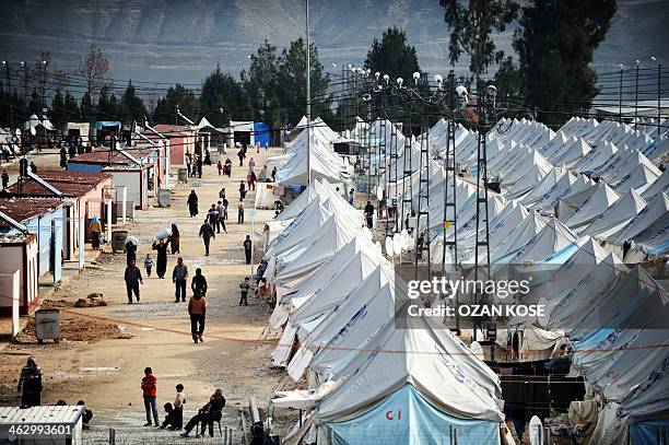 Syrian refugees walk among tents at Karkamis' refugee camp on January 16, 2014 near the town of Gaziantep, south of Turkey. Two weeks of battles...