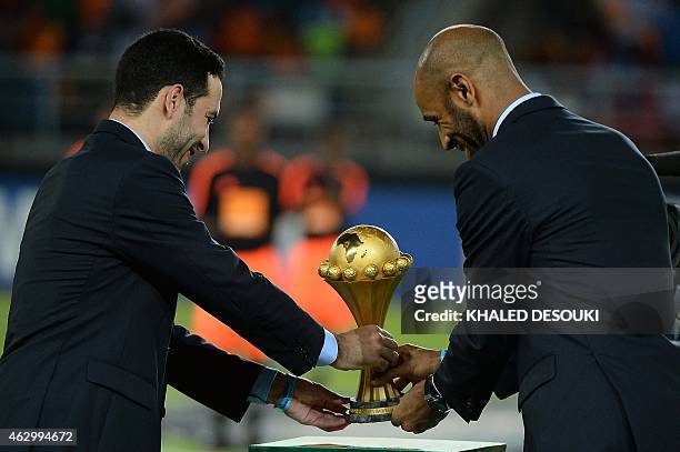 Malian forward Frederic Kanoute and Egyptian midfielder Mohamed Aboutrika deliver the 2015 African Cup of Nations trophy ahead of the final football...